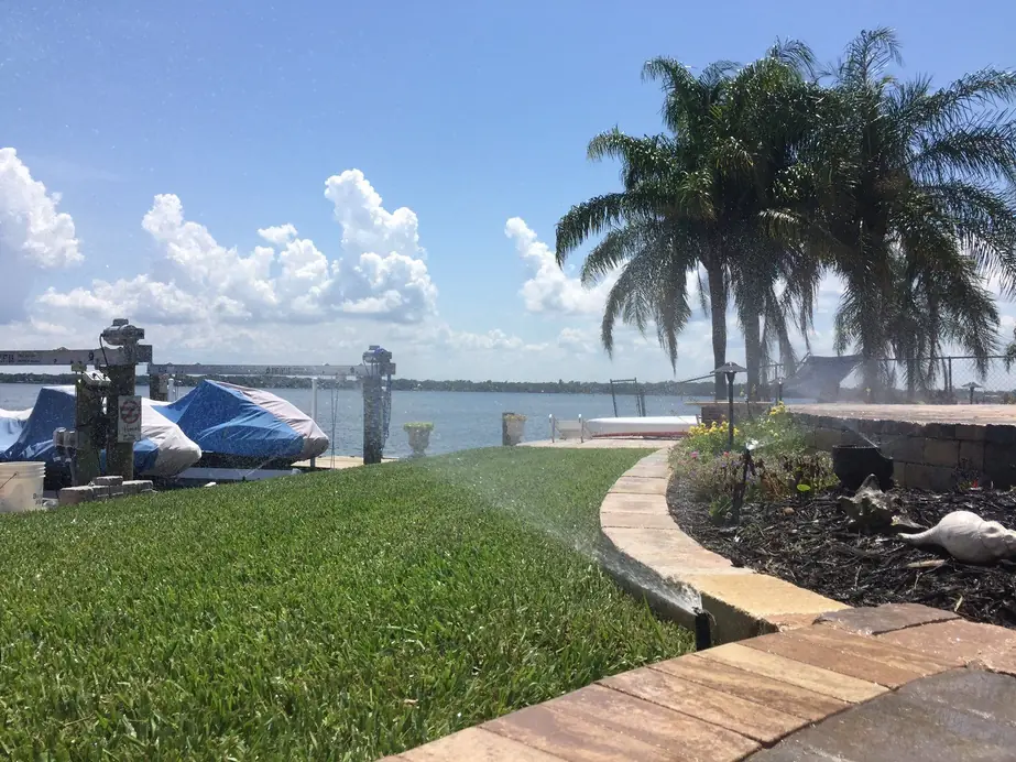 A Hartmann irrigation zone running on a waterfront Merritt Island property, dock and Indian River behind